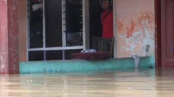 Seorang warga bertahan di rumahnya yang terendam banjir di Kota Tebingtinggi, Sumut, Senin (16/1/22/2019). (Foto: iNews/Abdullah Sani Hasibuan)