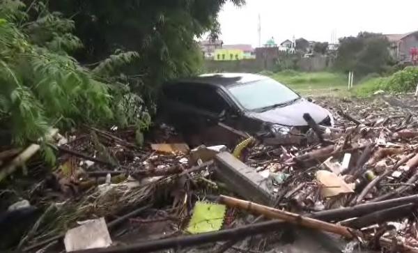 Mobil terseret arus di Desa Cimareme, Rabu (1/1/2020) (Foto: iNews/ Yuwono)
