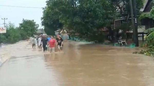 Warga Kabupaten Soppeng, Sulsel nekat menerjang banjir, Minggu (12/1/2020). (Foto: iNews/Amnar Sengkang)