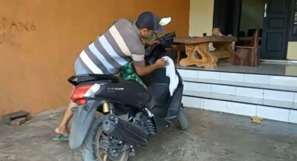 Wahyudi mengelap motornya, Jumat (17/1/2020) (Foto: iNews/Eris)