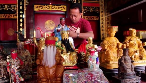 Juru Kunci Kelenteng Suryana  membersihkan patung, Selasa (21/1/2020) (Foto: iNews/Toiskandar)