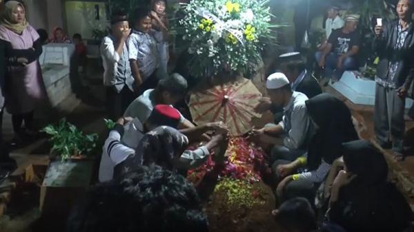 Keluarga saat mendoakan almarhum Brigpol Ahmad Jamsari saat pemakaman. (Foto: iNews/Roy M Perleoli)