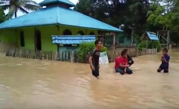 Anak-anak bermain air saat banjir merendam desa mereka di Penajam Paser Utara, Kaltim. (Foto: iNews/Mukmin Azis) 
