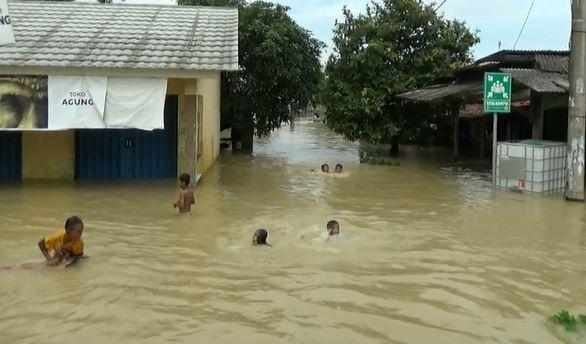 Anak-anak bermain banjir di Karawang Anak-anak bermain banjir di Karawang, Jumat (21/2/2020) (Foto: iNews/Fahruddin)