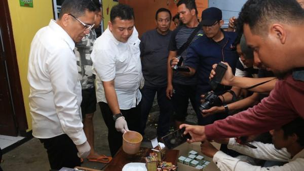 Dirreskoba Polda Jatim Kombes Pol Cornelis Maharagung Simanjuntak (berkacamata) menunjukkan barang bukti dari penggerebekan industri rumahan pembuatan obat kuat di Surabaya, Senin (24/2/2020). (Foto: iNews.id/Ihya` Ulumuddin)