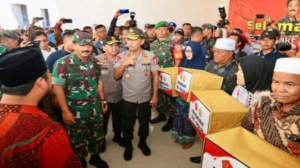 Panglima Kapolri Jenderal Pol Idham Azis disaksikan Panglima TNI Marsekal TNI Hadi Tjahjanto (kanan) menyerahkan bantuan kepada warga dalam acara bakti sosial di Pulau Galang, Batam, Kepri, Minggu (8/3/2020). (Foto: Puspen TNI).