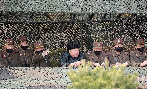 Pemimpin Korea Utara Kim Jong Un (tengah) menghadiri latihan oleh pasukan artileri militer di lokasi yang dirahasiakan. (FOTO: STR / KCNA MELALUI KNS / AFP)