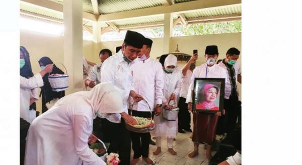 Presiden Jokowi menaburkan bunga di makam ibunya (Foto: Dok Keluarga)