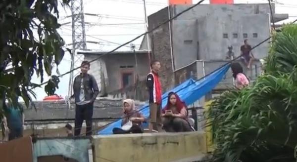 Warga mengungsi ke atap rumah saat banjir bandang menerjang Kota Cilegon. (Foto: iNews/Wimsalim)