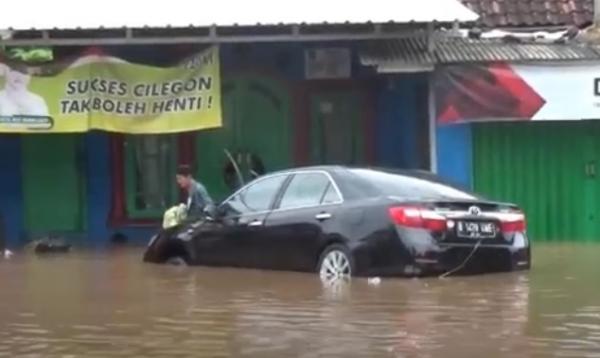 Mobil sedan terseret banjir bandang yang menerjang Kota Cilegon, Banten, Senin (5/4/2020). (Foto: iNews/Wimsalim)