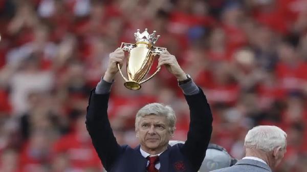 Arsene Wenger mengangkat trofi berlapis emas saat Arsenal juara Premier League 2003/2004 (foto: Premier League)