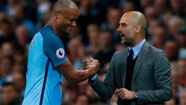 Pelatih Manchester City Pep Guardiola (kanan) berbincang dengan Vincent Kompany usai pertandingan beberapa waktu lalu. (Foto: The Sun)