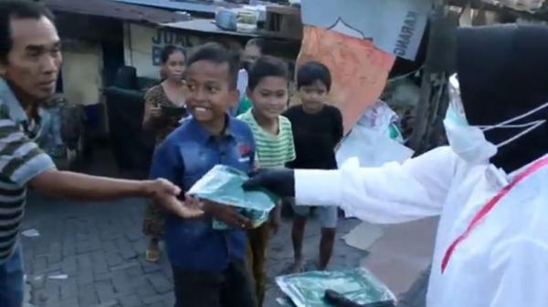 Wali Kota Surabaya Tri Rismaharini membagikan masker kepada warga saat berkeliling di kawasan Surabaya Barat, Surabaya, Jatim, Selasa (7/7/2020). (Foto: iNews/Hari Tambayong)