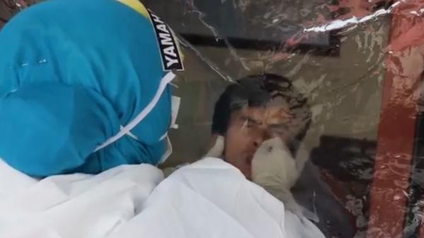 Swab-1 Petugas medis melakukan tes swab Covid-19 terhadap tahanan (Agung Sulistyo/iNews)