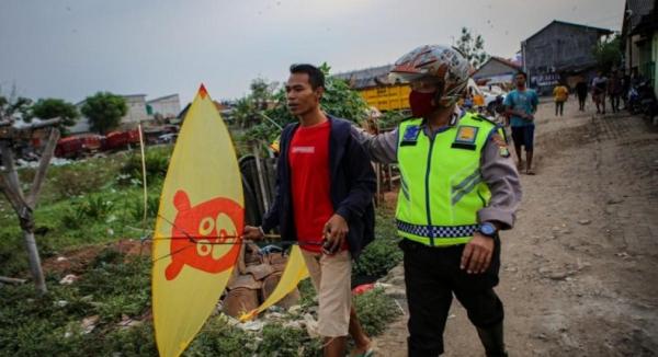Polisi membina warga yang menerbangkan layangan di dekat Bandara Soetta (Foto: Antara)