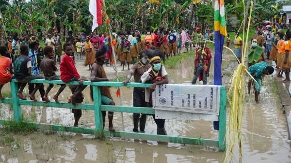 Warga menyambut kedatangan Kodim 1710/Mimika di tengah banjir yang melanda Kampung Kamora Distrik Mimika Tengah Papua, Sabtu (1/8/2020). (Foto: iNews/Nathan Making)