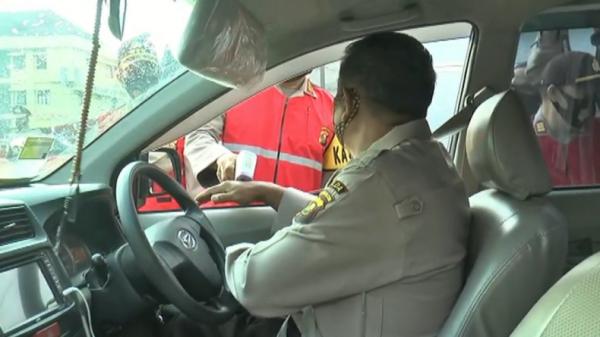 Kapolda Sumsel Irjen Pol Eko Indra Heri memegang thermogun untuk periksa suhu tubuh personel yang masuk (Muhammad David/iNews)