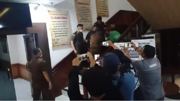 Tri Nugraha bersimbah darah usai menembak dirinya saat digotong petugas Kejati Bali. (iNews.id)