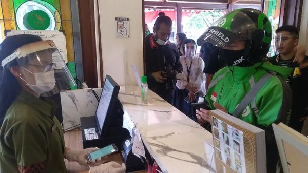 Merchant Go Food Resto Gama Ikan Bakar dan Seafood melakukan pelayanan kepada mitra driver. (Foto: Arif Budianto)