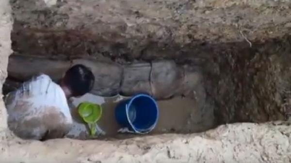 Santri menguras air di makam jasad KH Ahmad Baidowi yang ditemukan masih utuh di Sampang, Madura, Jatim. (Foto: Istimewa/iNews/Tikno Arie)