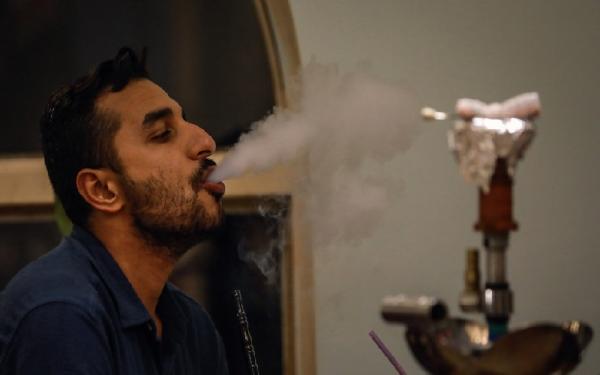 Seorang pria tengah menikmati rokok shisha yang jadi kebiasaan warga Turki saat bersantai bersama rekan-rekan. (foto: Russia Today)