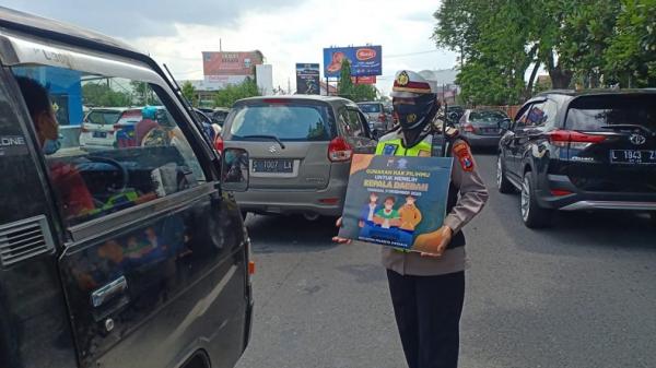 Sejumlah Polantas Polresta Sidoarjo menggelar sosialisasi ajakan kepada warga untuk menggunakan hak suara pada Pilkada Serentak 2020 besok. (Foto: iNews/Pramono Putra)