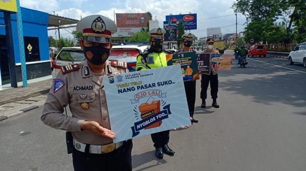 Sejumlah Polantas Polresta Sidoarjo menggelar sosialisasi ajakan kepada warga untuk menggunakan hak suara pada Pilkada Serentak 2020 besok. (Foto: iNews/Pramono Putra)