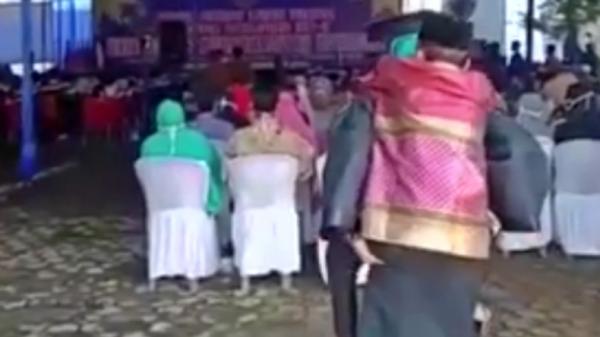 Jefri, mahasiswa asal Lampung Utara ketika menggendong ayahnya yang lumpuh saat hadiri wisuda (Jimi Irawan/iNews)
