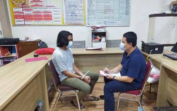 Penyerang polisi Pontianak 2 Polisi memeriksa RDS (21), pelaku penyerangan polisi saat aksi 1812 mendukung Habib Rizieq si Pontianak. (iNews.id/Gusti Eddy)