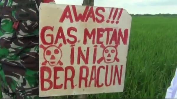 Karton berisi tulisan memperingatkan agar warga berhati-hati saat mendekati semburan diduga gas. (Foto: iNewsTv/Yudy Hermawan Juanda)