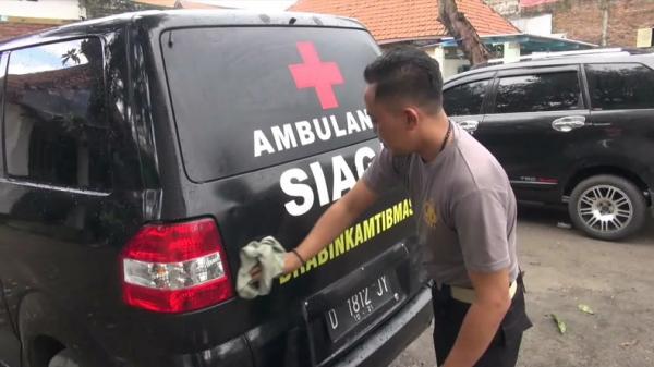Bripka M Fathurrozi, Bhabinkamtibmas Polresta Sidoarjo membersihkan mobil pribadinya yang disulap jadi ambulans untuk melayani warga Desa Krembangan Taman, Kabupaten Sidoarjo. (Foto: iNews/Pramono Putra)
