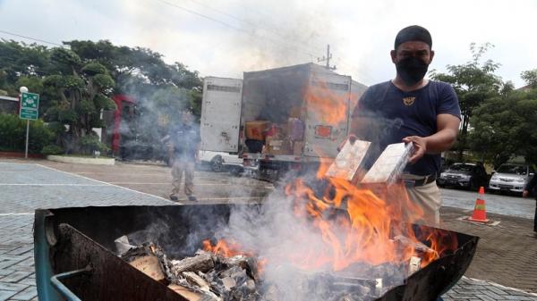 Petugas Bea Cukai memusnahkan barang bukti rokok ilegal dan sex toys di halaman kantor Bea Cukai Juanda, Jawa Timur, Rabu (03/3/2021). (Foto: SINDONews/Ali Masduki)
