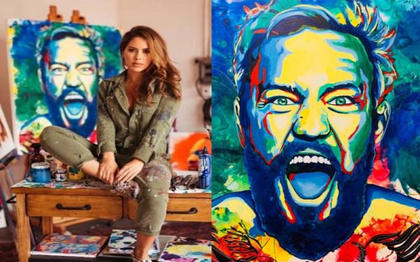 Brittney Palmer Brittney Palmer berpose di depan karyanya yakni lukisan wajah Conor McGregor. (Foto: Instagram)