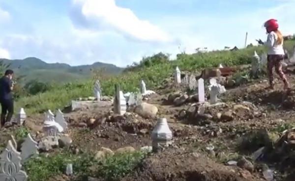 Warga melihat kondisi tujuh makam di pemakaman khusus Covid di Parepare terbongkar. (Foto: iNews/Ichsan Anshari)