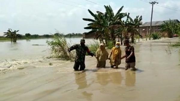 Anggota BPBD dan TNI membantu warga di lokasi banjir di kawasan Kecamatan Balongpanggang, Kabupaten Gresik, Jatim, Senin (15/3/2021). (Foto: SINDOnews/Ashadi Iksan)