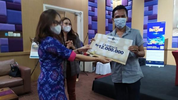 Branch Manager MNC Bank KC Bali Herning Setiawati menyerahkan hadiah kepada para nasabah pemenang undian tabungan arisan, Rabu (17/3/2020). (Foto: SINDONews/Chusna Mohammad)