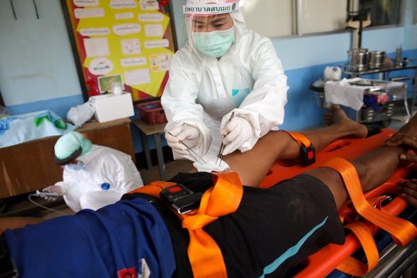 Petugas kesehatan di Desa Mae Sam Laep, Thailand, merawat pengungsi Myanmar yang terluka, Selasa (30/3/2021). (Foto: Reuters)