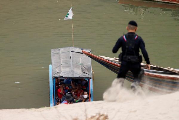 Perahu pengangkut pengungsi Myanmar merapat di tepian Sungai Salween yang dijaga tentara Thailand, Senin (29/3/2021). (Foto: Reuters)