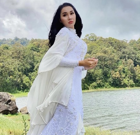 Lucinta Luna memakai gaun putih panjang.