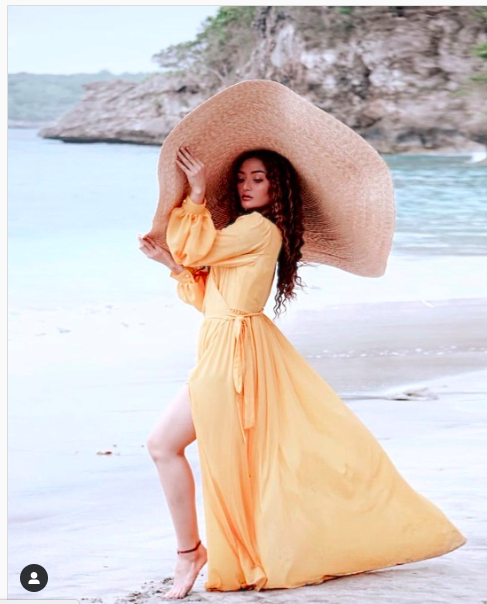 Siti Badriah bergaya mengenakan busana buatan desainer lokal di pantai (Foto: Instagram)