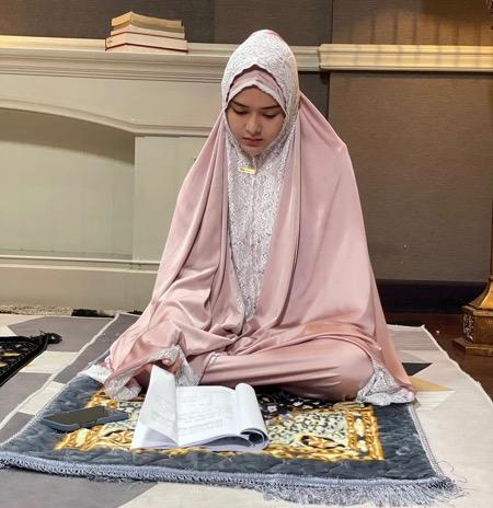 Amanda M Amanda memakai mukena dengan detail renda.