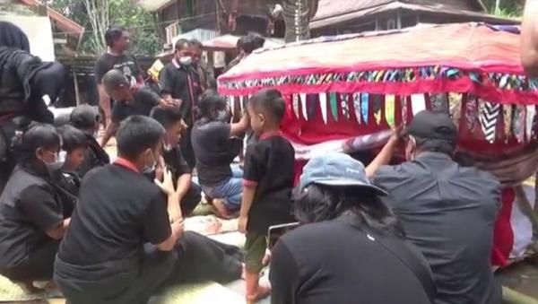 Keluarga menggelar prosesi adat Toraja sebelum memakamkan jenazah Oktovianus Rayo (42), di Desa Sadan Pebulian, Kabupaten Toraja Utara, Sulsel, Sabtu (17/4/2021). (Foto: iNews/Jufri Tonapa)