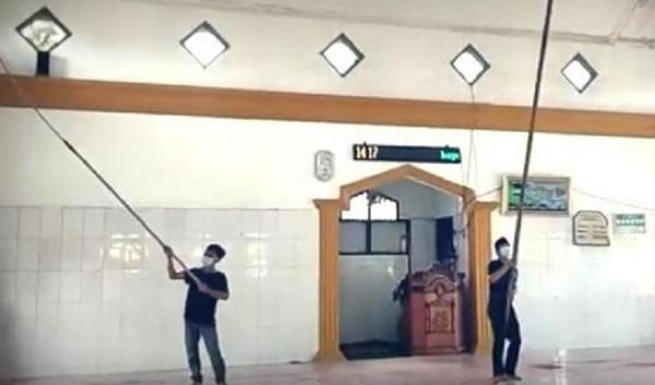 Angrit dan Ukan sedang membersihkan masjid yang disinggahi. (Foto: istimewa)