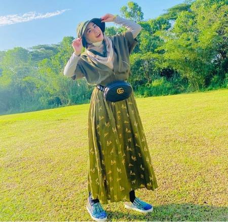 April Jasmine dengan busana hijau.