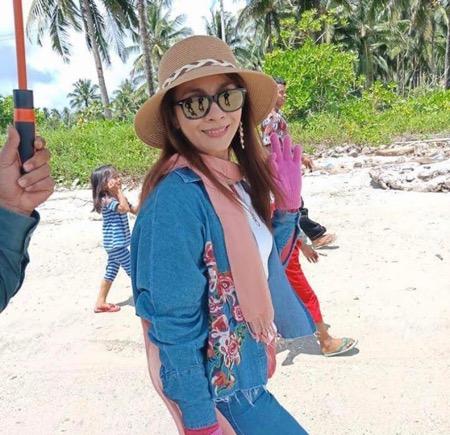 Sri Wahyumi Maria Manalip memakai topi.