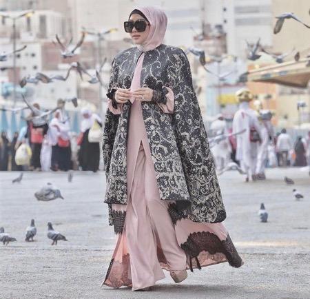 Syahrini cape Syahrini dengan model busana cape.