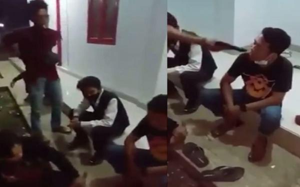 Pria berbaju merah mencabut benda berbentuk pistol dari pinggang belakang. Korek api berbentuk pistol itu ditodongkan ke wajah korban. (Foto: tangkapan layar video viral)