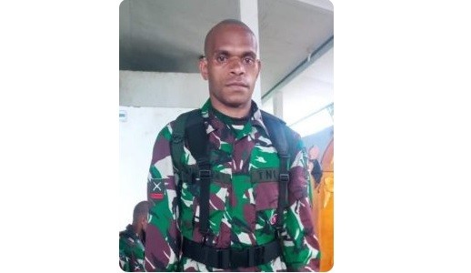 Bocah Papua Danrem 151/Binaya Brigjen TNI Arnold AP Ritiauw menyerahkan foto dan bendera Merah Putih kepada Dalimahu Talaohu, istri almarhum Praka M Alif Nur Angkotasan saat upacara pemakaman secara militer di Negeri Pelauw, Pulau Haruku. (Foto: Antara)