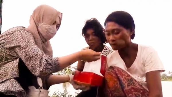 WANITA CANTIK PEDULI ODGJ2 Ani Sumarni menyuapi ODGJ yang ditemuinya di jalan. (Foto: iNews/M Andi Ichsyan)