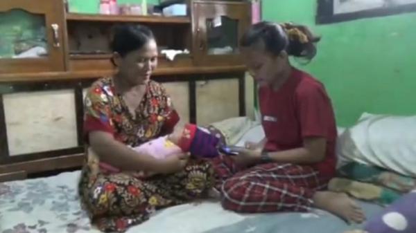 BERSALIN DI RUMAH1 Titi Marsiti menimang bayi yang baru dilahirkan dan Lia, putrinya yang membantu proses persalinan. (Foto: iNews/Irwan)